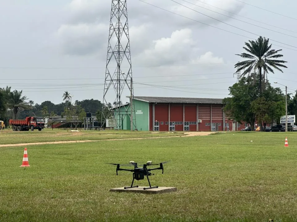 Drone posé sur l'aire de décollage balisée du centre, devant les hangars