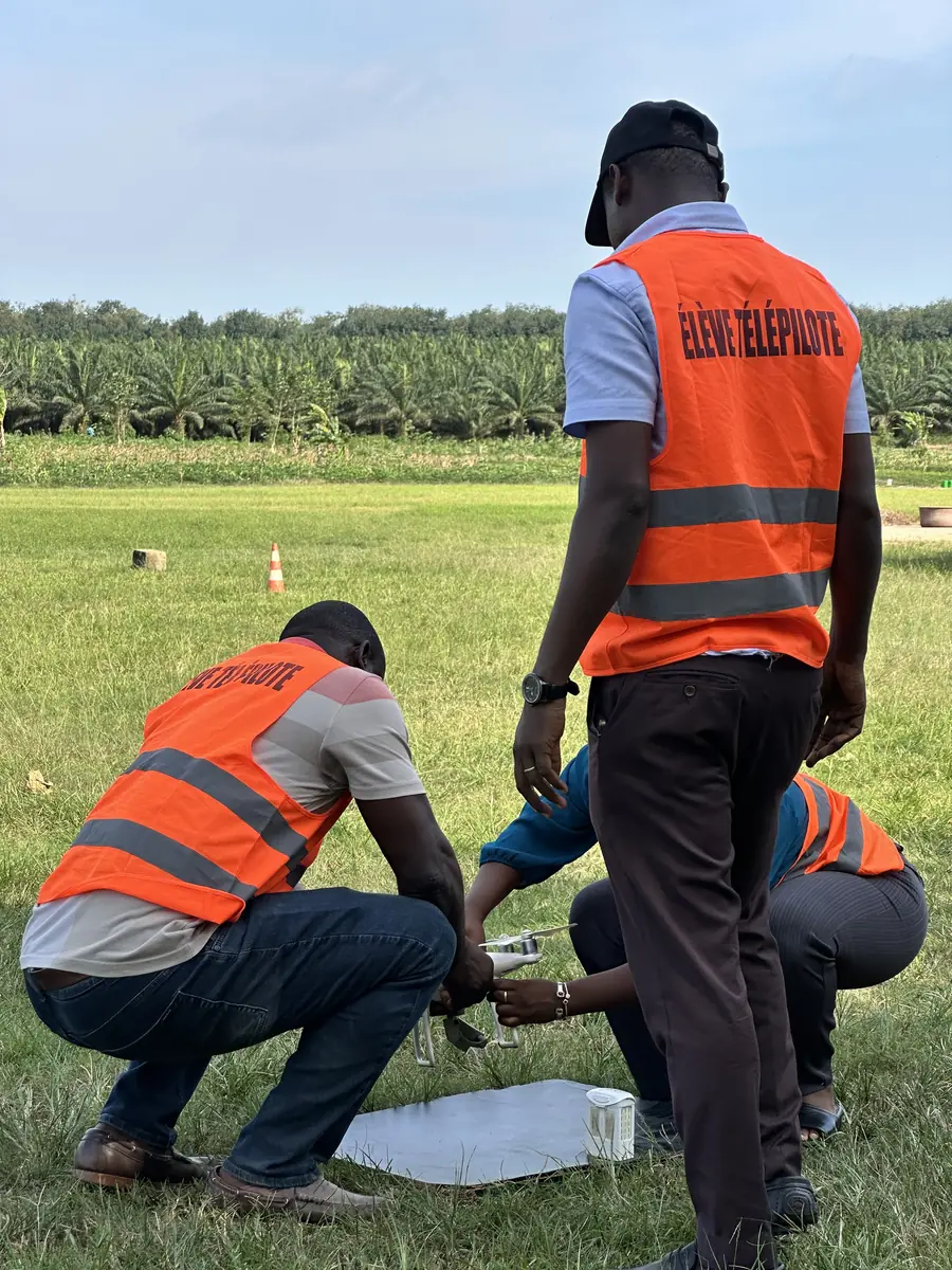 Stagiaires préparant un drone sur l'aire de décollage