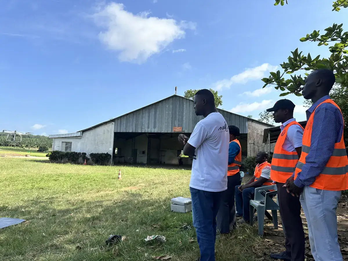 Stagiaires sur la parcelle d'application, devant le hangar